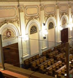 Interiér historického sálu s řadami židlí a bohatou štukovou výzdobou