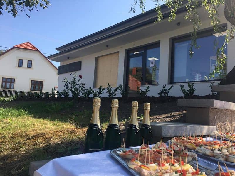 Slavnostní stůl s občerstvením a šampaňským před novou budovou