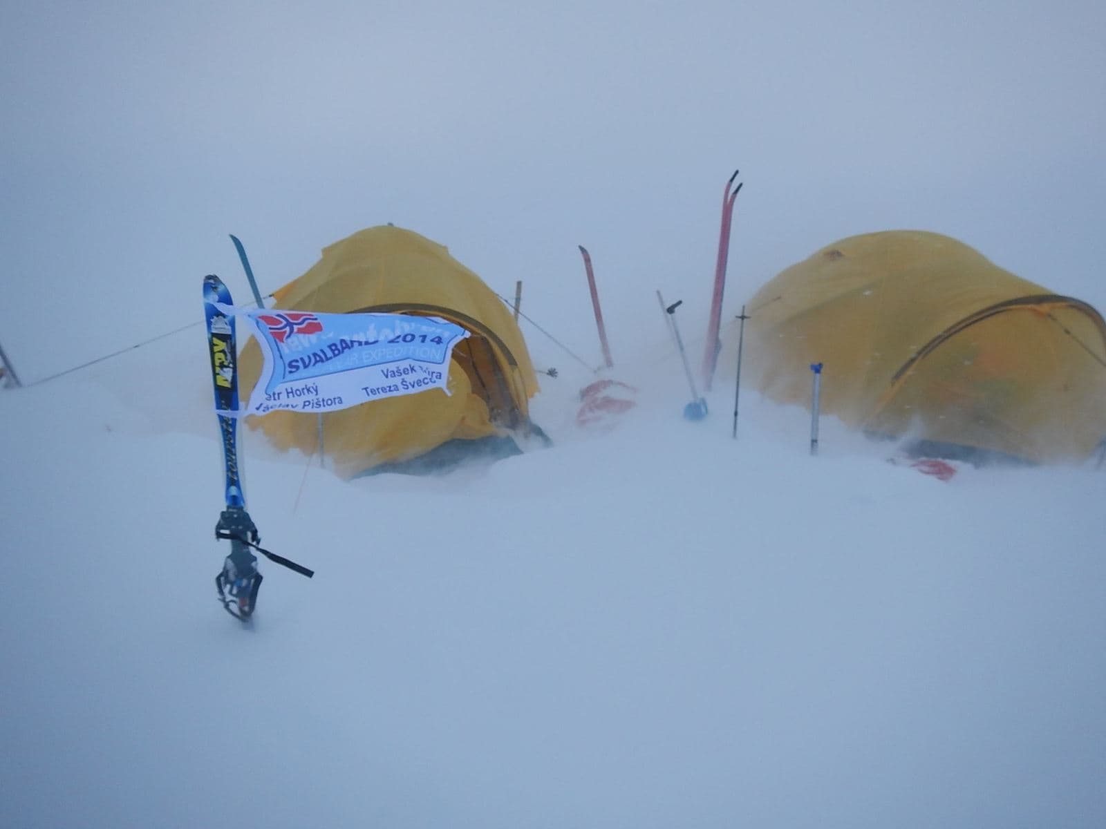 Dva žluté stany v zasněžené krajině, vlajka Svalbard 2014 Expedition