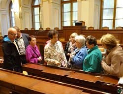Skupina lidí v historické místnosti s dřevěným obložením