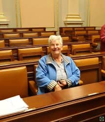Usmívající se žena sedící v lavici v zasedací místnosti