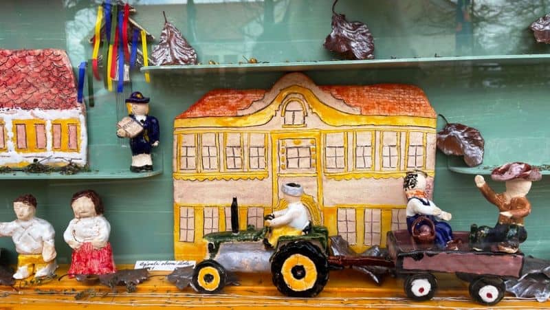 Keramické figurky a domy v prosklené vitríně