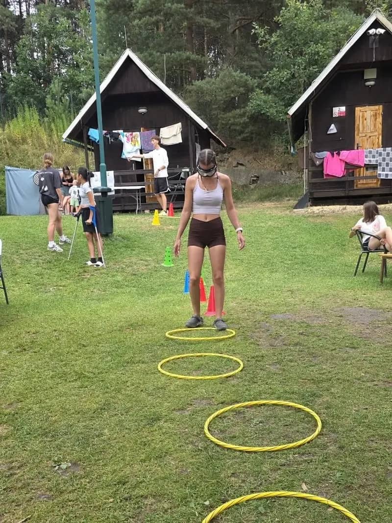 Dítě prochází trasou vyznačenou obručemi na trávě.