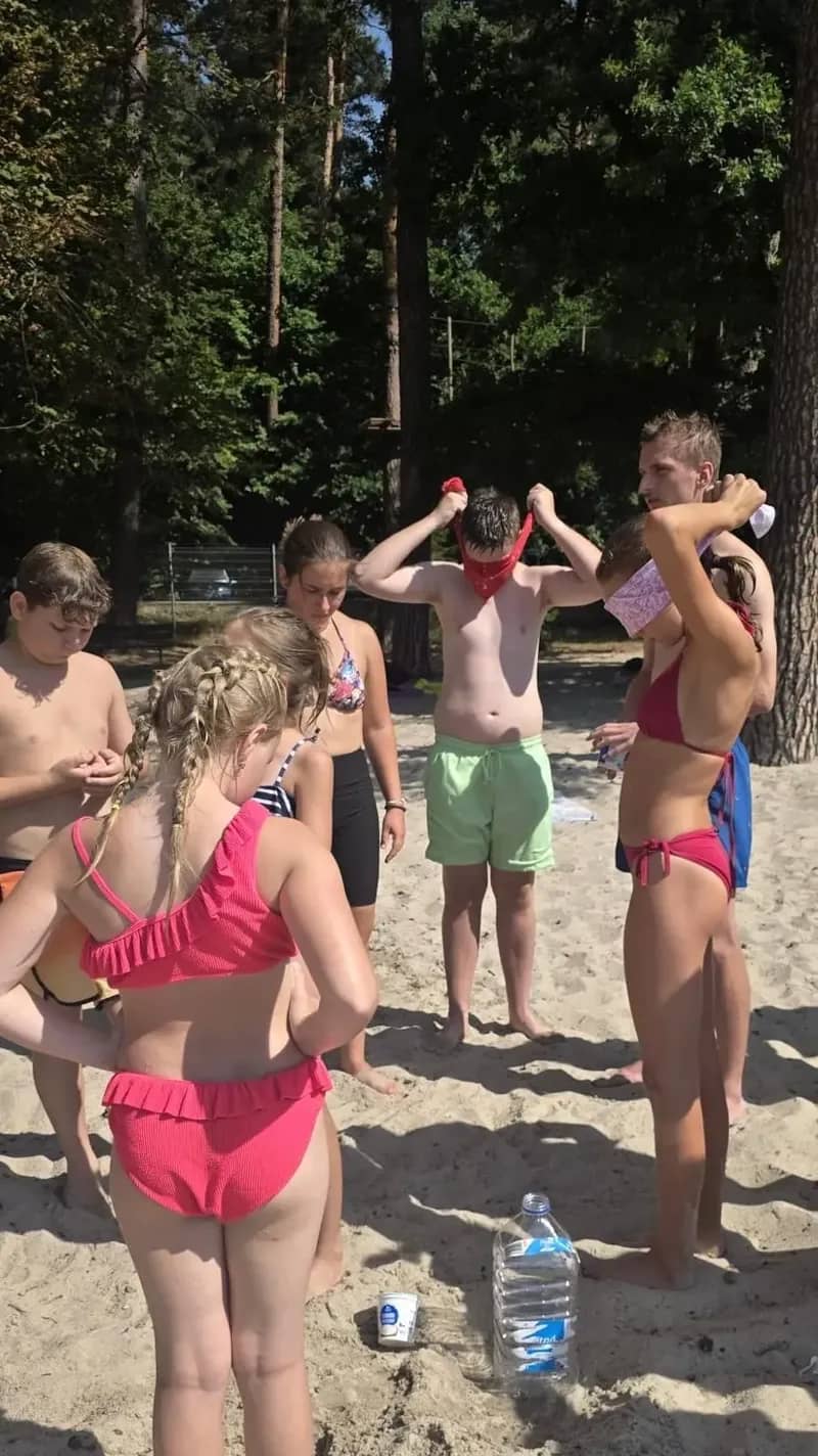Skupina dětí v plavkách při venkovní hře.