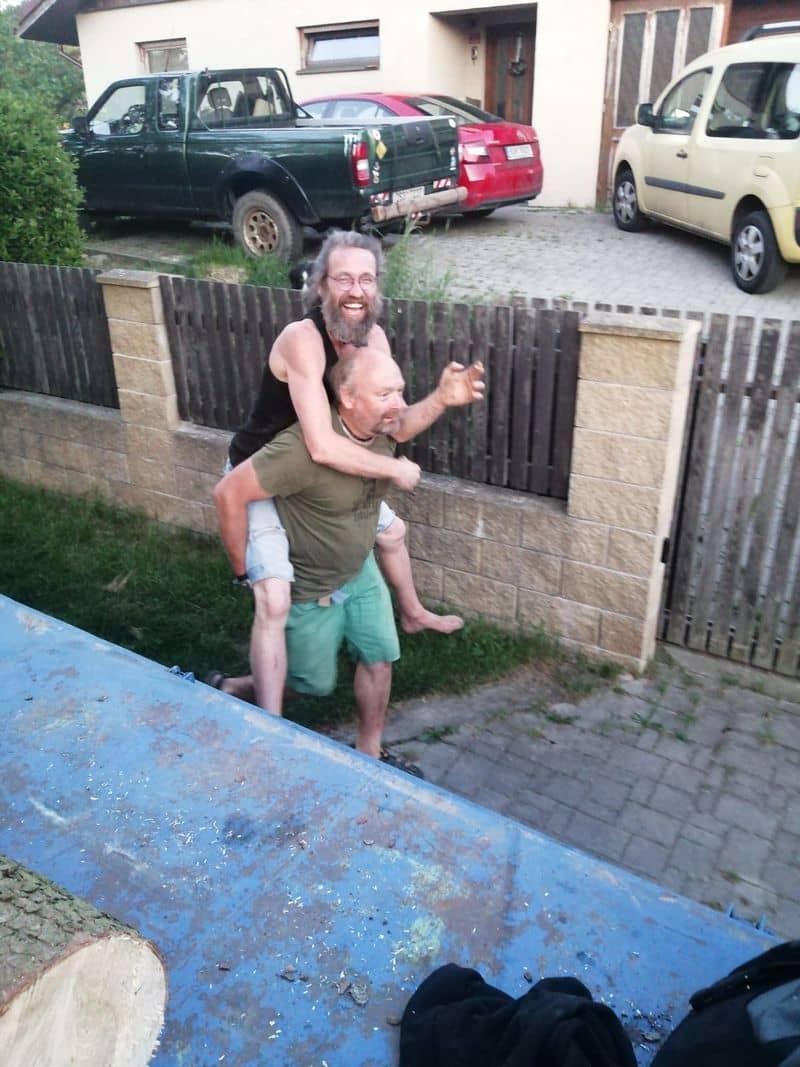 Dva muži se smějí, jeden nese druhého na zádech