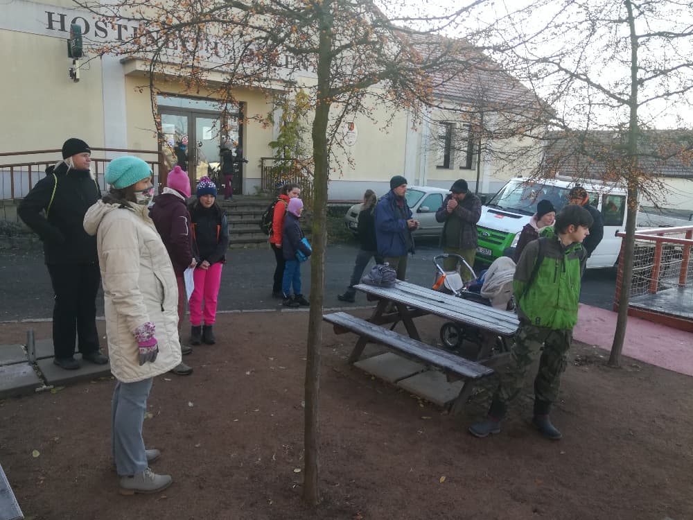 Skupina lidí před budovou s nápisem HOSTINEC