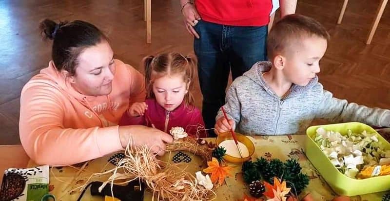 Žena s dětmi tvoří podzimní dekorace