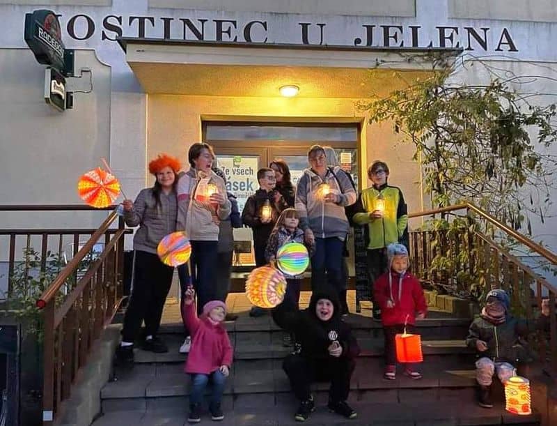 Skupina dětí a dospělých s lampiony před hostincem U Jelena