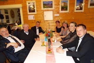Skupina sedmi lidí u stolu v dřevěné místnosti