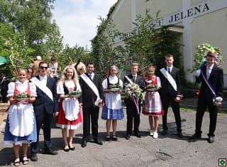 Skupina mladých lidí v krojích a oblecích s šerpami