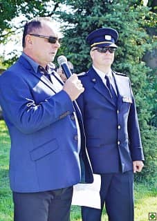 Muž s mikrofonem a muž v uniformě s medailemi