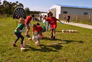 Děti hrají hru s dřevěnými špalky na trávě
