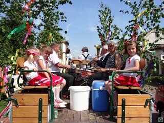 Děti a muzikanti na nazdobeném voze