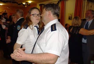 Muž a žena v uniformách tančí na plese