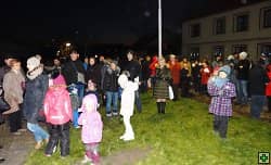 Skupina lidí a dětí na trávníku za tmy