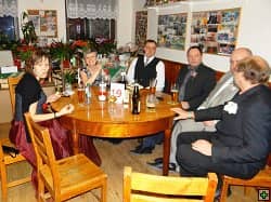 Skupina šesti lidí sedí u stolu v restauraci