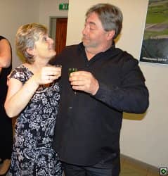 Žena a muž s drinky se na sebe usmívají