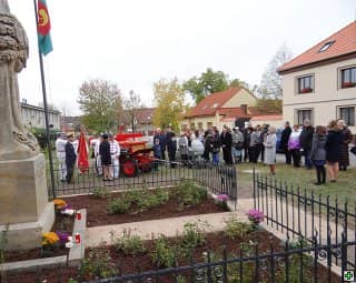 Skupina lidí u pomníku, hasiči s praporem a historickou stříkačkou