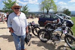 Muž v klobouku u historických motocyklů