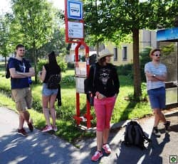 Čtyři lidé čekají na autobusové zastávce