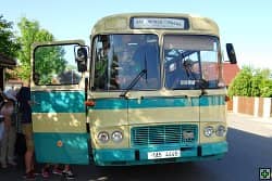 Historický autobus s otevřenými dveřmi a cestujícími