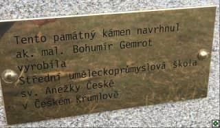 Pamětní deska s textem: Tento památný kámen navrhnul ak. mal. Bohumír Gemrot, vyrobila Střední uměleckoprůmyslová škola sv. Anežky České v Českém Krumlově