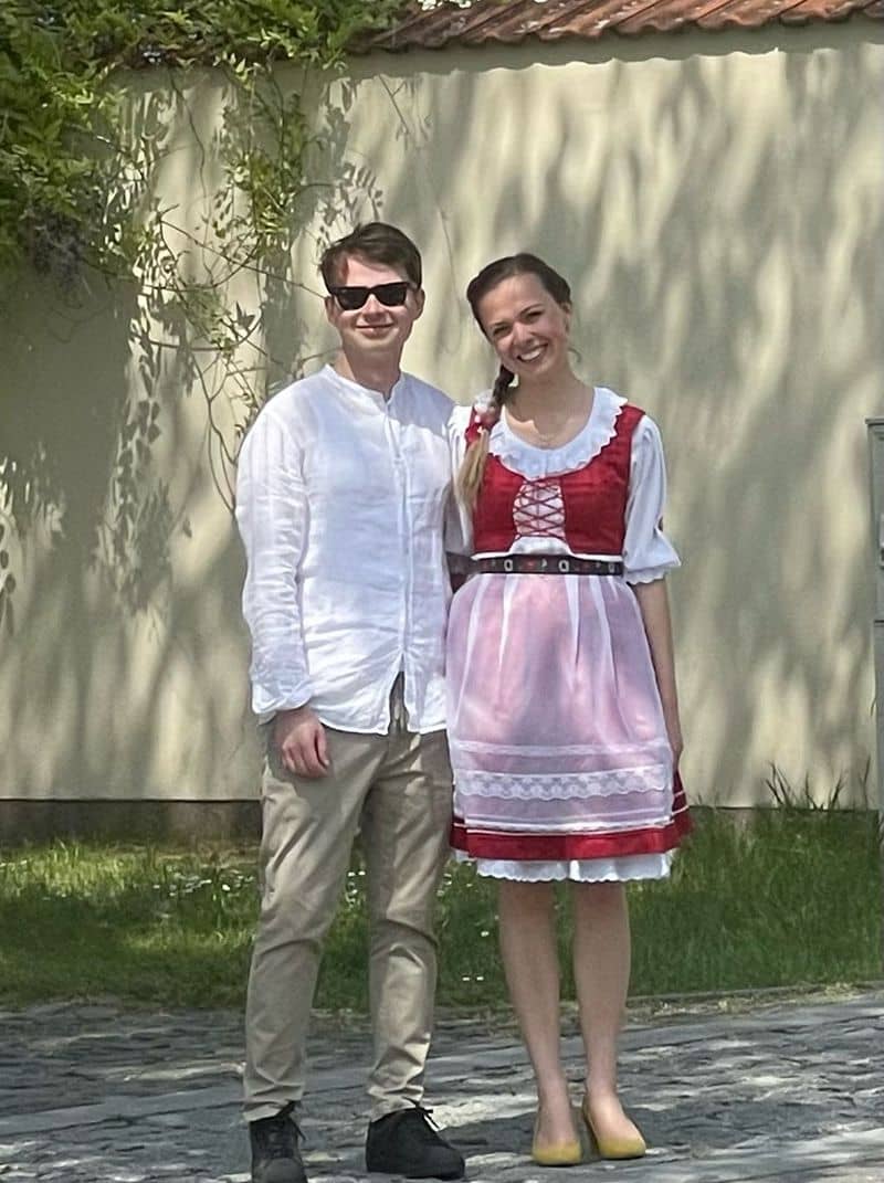 Muž v bílé košili a žena v kroji se usmívají