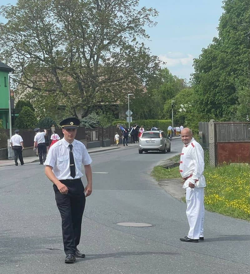 Muži v uniformách a krojích na silnici