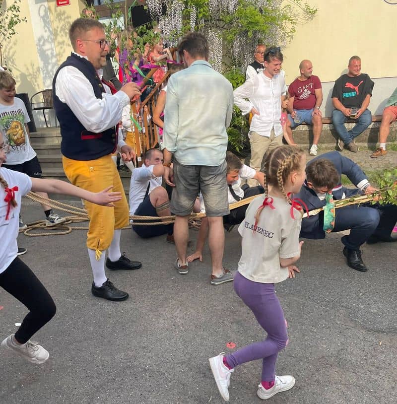 Skupina lidí a dětí při přetahování lana